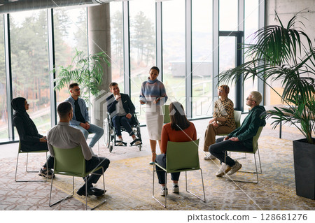 Corporate business team meeting with a manager or coach. Group of happy diverse, multiracial people sitting in a circle  128681276