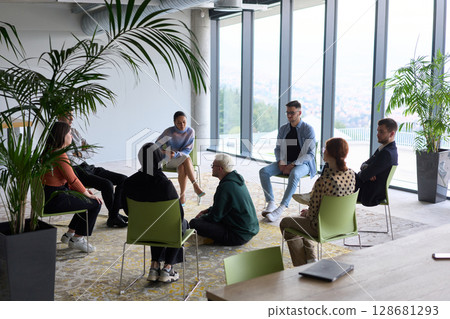 Corporate business team meeting with a manager or coach. Group of happy diverse, multiracial people sitting in a circle Corporate business team meeting with a manager or coach. Group of happy diverse, multiracial people sitting in a circle 128681293