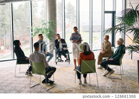 Corporate business team meeting with a manager or coach. Group of happy diverse, multiracial people sitting in a circle  128681308