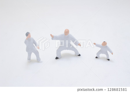 Miniature Figurine of a Martial Artist in Combat Pose Over White Background Miniature Figurine of a Martial Artist in Combat Pose Over White Background 128681581