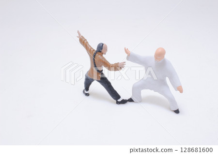 Miniature Figures Demonstrating Martial Arts Poses on a White Background Miniature Figures Demonstrating Martial Arts Poses on a White Background 128681600