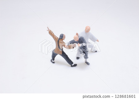 Miniature Figures Demonstrating Martial Arts Poses on a White Background Miniature Figures Demonstrating Martial Arts Poses on a White Background 128681601