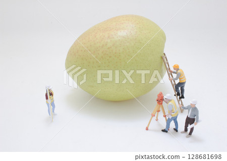 Miniature Workers Operating on a Giant Pear for Surreal Art 128681698