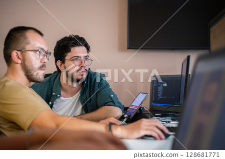 Programmers engrossed in deep collaboration, diligently working together to solve complex problems and develop innovative mobile applications with seamless functionality. Programmers engrossed in deep collaboration, diligently working together to solve complex problems and develop innovative mobile applications with seamless functionality. 128681771