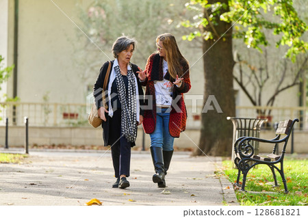 Autumn Walk: A Mother and Daughter Share Love and Support in Natures Embrace. Autumn Walk: A Mother and Daughter Share Love and Support in Natures Embrace. 128681821