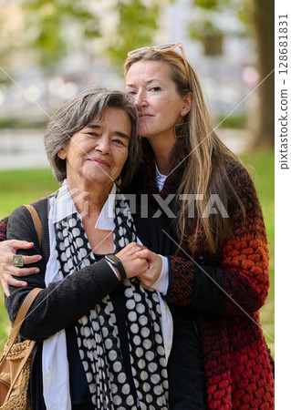 A Heartfelt Embrace: A Daughters Support for Her Mother on a Beautiful Autumn Day. 128681831