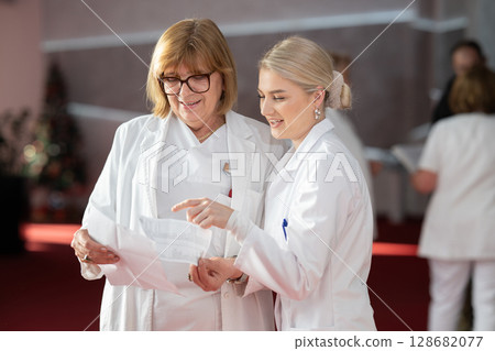 Group of female doctors reviewing medical document 128682077