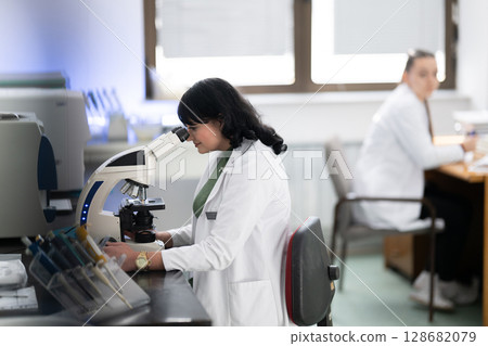 Doctor scientist using microscope in laboratory 128682079