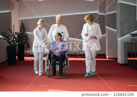 Doctor checking patients progress in wheelchair 128682100
