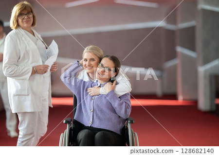 Doctor checking patients progress in wheelchair 128682140