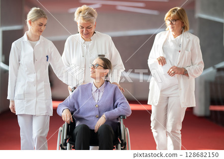 Doctor checking patients progress in wheelchair Doctor checking patients progress in wheelchair 128682150