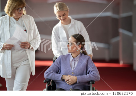 Doctor checking patients progress in wheelchair 128682170