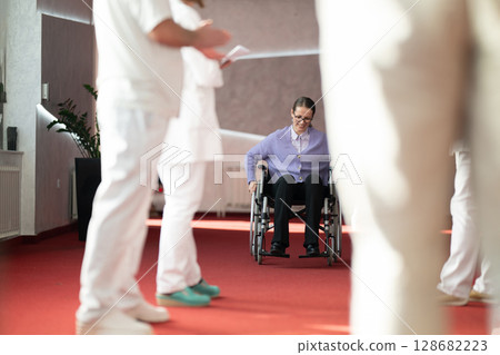 Woman in wheelchair participating in therapy session 128682223