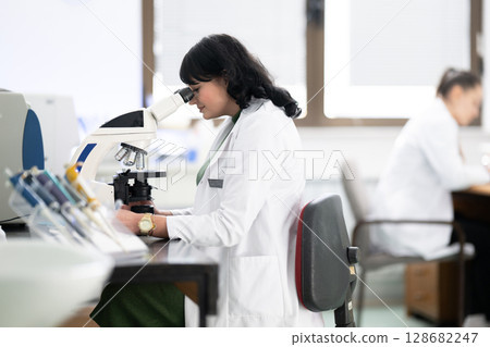 Doctor scientist using microscope in laboratory 128682247