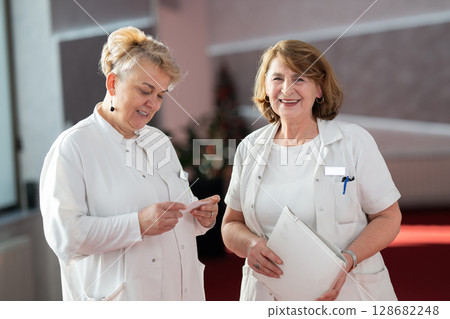 Group of female doctors reviewing medical document 128682248