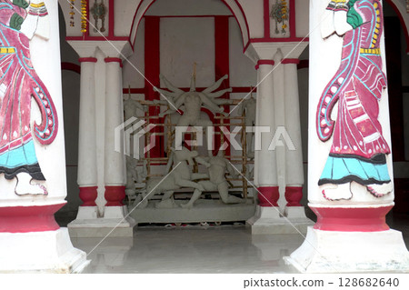 Symmetrical View of Unfinished Durga Idol in Heritage Courtyard with Painted Pillars 128682640
