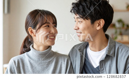 Smiling couple in their 20s looking at each other Smiling couple in their 20s looking at each other 128682837