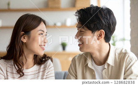 一對 20 多歲的夫婦微笑地看著對方 128682838