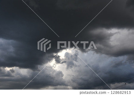 Dramatic dark storm thundercloud rain clouds on black sky background. Dark thunderstorm clouds rainny landscape. Meteorology danger windstorm disaster climate. Dark cloudscape storm disaster gray sky 128682913