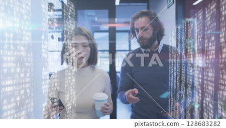 Screens with data processing against diverse male and female office colleagues discussing at office 128683282