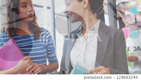 Statistical data processing against two caucasian businesswomen discussing at office Statistical data processing against two caucasian businesswomen discussing at office 128683294