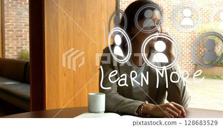 Image of media icons and learn more text over biracial businesswoman talking on smartphone 128683529
