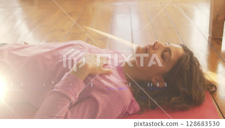 Image of light spots over caucasian woman lying on floor Image of light spots over caucasian woman lying on floor 128683530