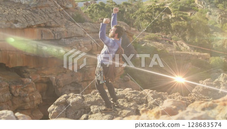 Image of light trails over caucasian man with arms outstretched 128683574