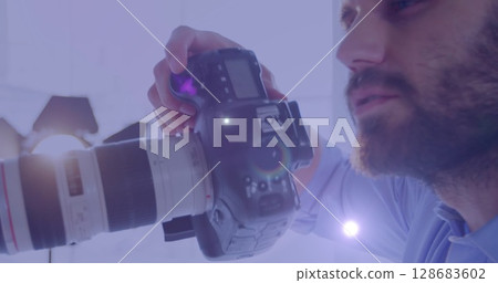 Spot of light against caucasian male photographer clicking pictures with digital camera 128683602