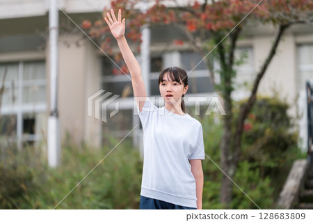 A female student in gym clothes taking an oath at a sports festival A female student in gym clothes taking an oath at a sports festival 128683809