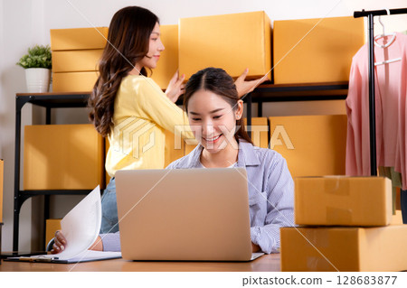 Two young asian businesswoman checking order of customer for laptop computer and document. Two young asian businesswoman checking order of customer for laptop computer and document. 128683877