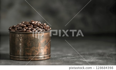 Roasted coffee beans fill a rustic metal container against a dark background, showcasing a rich aroma and inviting coffee experience. 128684398