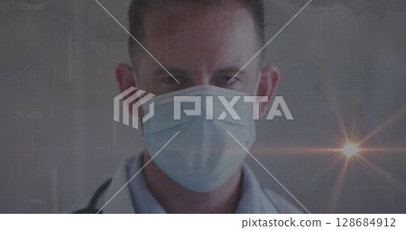 Posing doctor wearing white coat and surgical mask with stethoscope in clinic, with data overlay Posing doctor wearing white coat and surgical mask with stethoscope in clinic, with data overlay 128684912