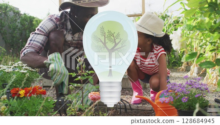 Image of light bulb with tree over african american father and daughter in garden Image of light bulb with tree over african american father and daughter in garden 128684945
