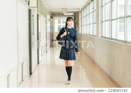 Female students, elementary school students, junior high school students, and high school students in uniform walking down a school corridor Female students, elementary school students, junior high school students, and high school students in uniform walking down a school corridor 128685191