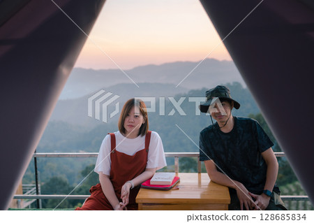 asian couple relax with travel in honeymoon trip with mountain background 128685834