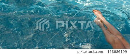 A girl's feet in a blue pool. Epilation of legs, varicose veins. Rest, relaxation on the beach, at the hotel. A woman in freedom. Vacation. High quality photo 128686199