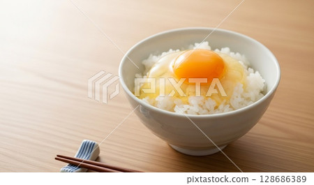 A bowl of Japanese rice topped with a soft-boiled egg. 128686389