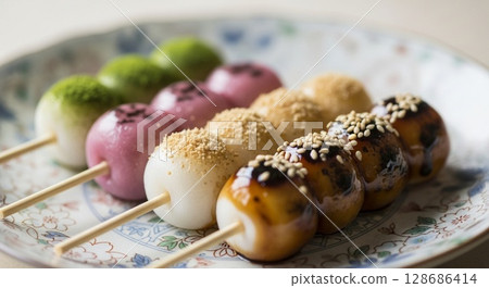 Colorful Japanese sweet treats, dango, arranged on a plate, showcasing various colors and toppings. 128686414