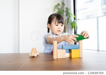 Educational scene of a young girl playing with building blocks 128686769