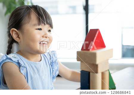 Educational scene of a young girl playing with building blocks 128686841