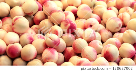 Horizontal full background with ripe nectarines. Fresh nectarine for sale on street market, Southeast Asia. Fresh fruits in a traditional morning market, Myanmar 128687002
