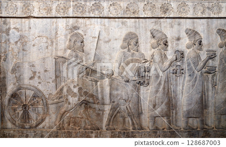 Ancient wall with bas-relief with assyrian warriors, horses and foreign ambassadors with gifts and donations, Persepolis, Iran. Topic of travel, trip abroad on vacation, cruises and tours 128687003