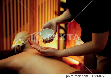 Masseuse prepare oil massage procedure for customer at spa. Quiescent 128687298