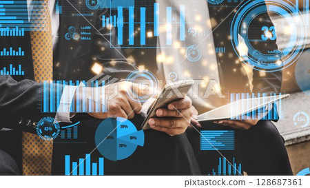Business professionals analyzing digital data charts and graphs on mobile devices in a modern office environment with overlay graphics and statistics xenic Business professionals analyzing digital data charts and graphs on mobile devices in a modern office environment with overlay graphics and statistics xenic 128687361