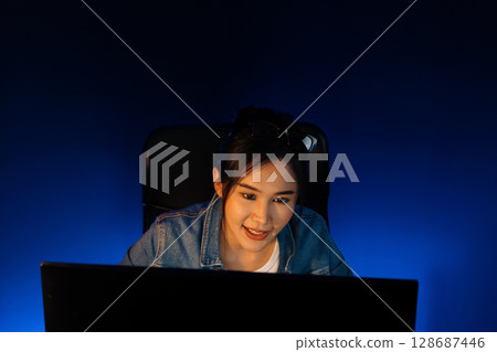 Smiling beautiful asian creative looking pc in sales target online. Stratagem. Smiling beautiful asian creative looking pc in sales target online. Stratagem. 128687446