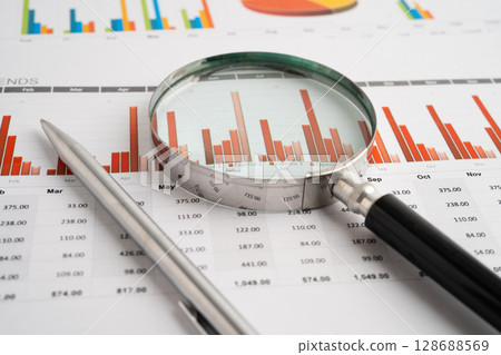 Magnifying glass on spreadsheet and graph paper. Financial data economy, Business. 128688569