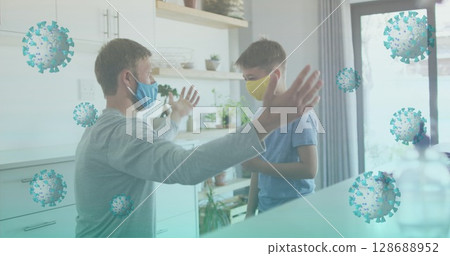 Wearing face masks, father and son keeping distance in modern home kitchen, with coronavirus icons Wearing face masks, father and son keeping distance in modern home kitchen, with coronavirus icons 128688952