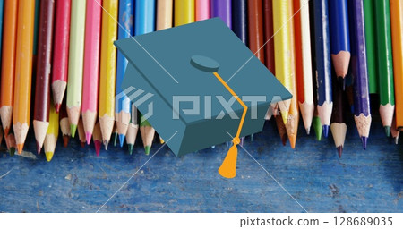 Image of mortarboard moving over coloured pencils on desk Image of mortarboard moving over coloured pencils on desk 128689035