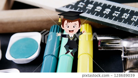 Image of excited schoolboy moving over coloured pens and school stationery Image of excited schoolboy moving over coloured pens and school stationery 128689039